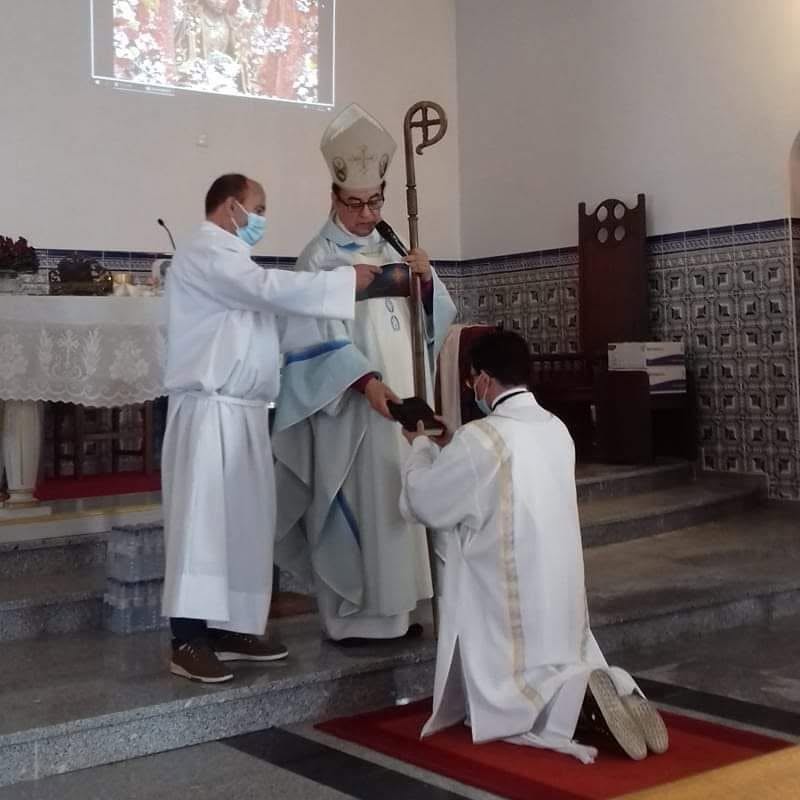 Ordenação diaconal de Carlos Fonseca, Santuário do Senhor Santo Cristo, Murgueira, Mafra, 5 de outubro de 2020 - Carlos Fonseca ajoelhado em túnica branca diante de Dom António Raposo, Arcebispo Primaz da Igreja Apostólica Episcopal (Vetero‑Católica), durante a cerimónia